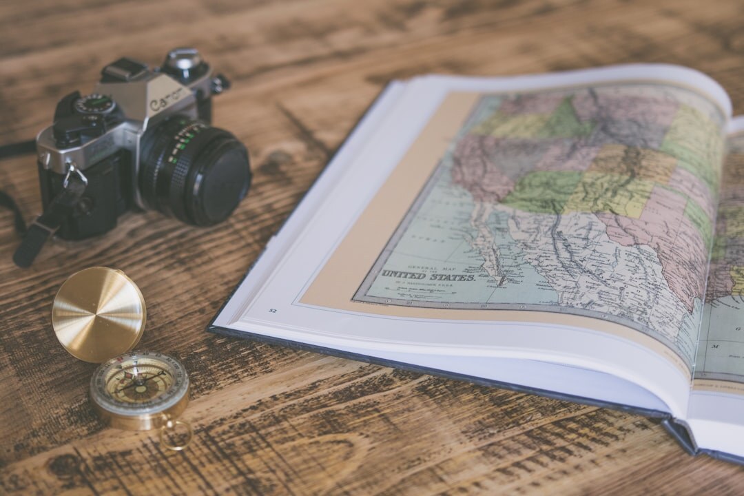 Book cover with an old map and compass on dark wood