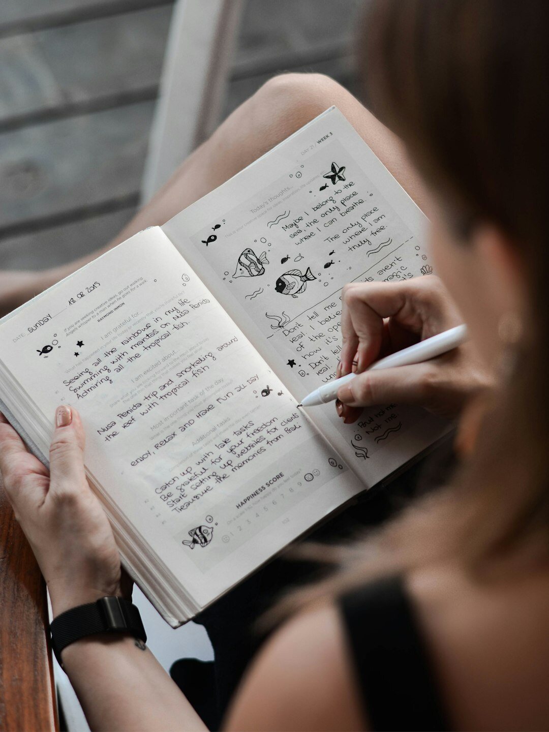 person writing notes on book