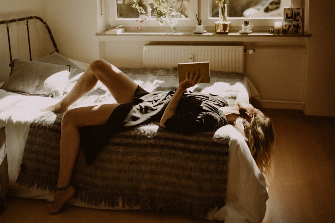 woman reading thriller in bed